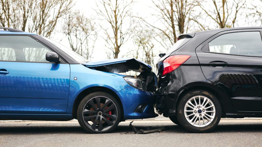 Two cars involved in a rear-end collision on a rural road.